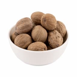 Whole nutmeg spice placed on a wooden board with grated nutmeg